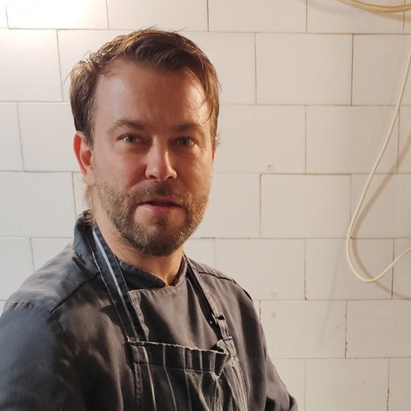 Portrait of Chef Tamás, head chef, in his dark chef jacket